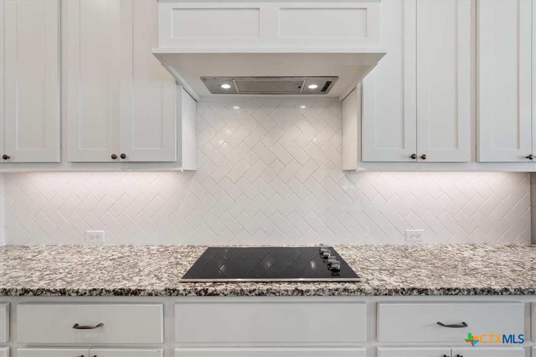 102 Rancho Del Lago Lane Belton, TX 76513 - Photo 13 of 40 a kitchen with white cabinets and appliances