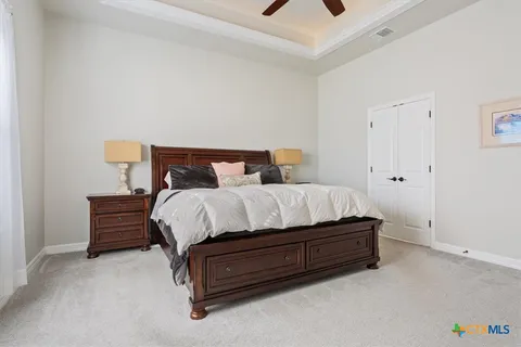 a bedroom with a bed and a flat tv screen on dresser