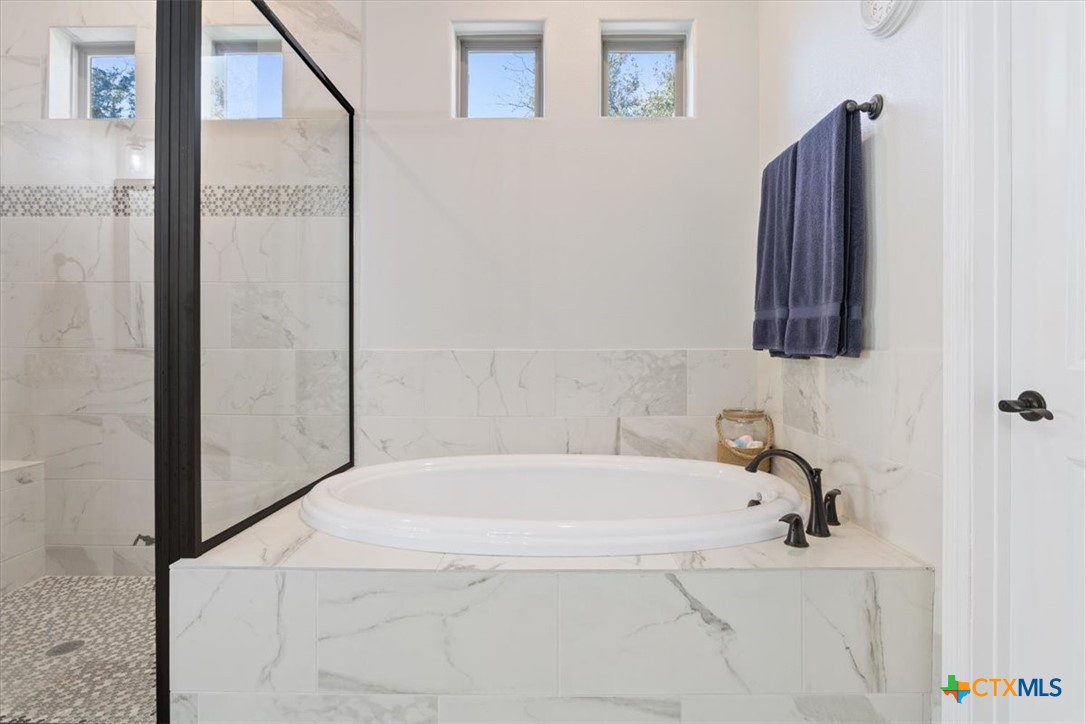 102 Rancho Del Lago Lane Belton, TX 76513 - Photo 20 of 40 a bathroom with a white tub and shower