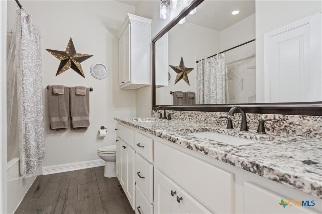 102 Rancho Del Lago Lane Belton, TX 76513 - Photo 27 of 40 a bathroom with a granite countertop sink a toilet and a mirror