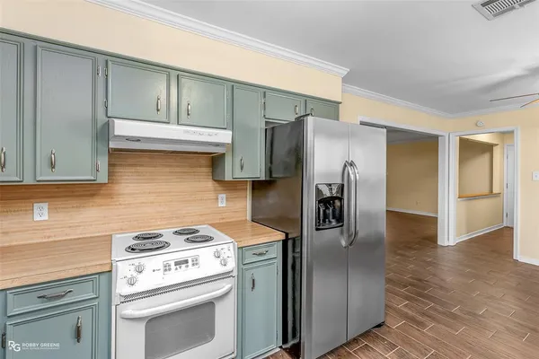 a kitchen with stainless steel appliances white cabinets and a stove top oven