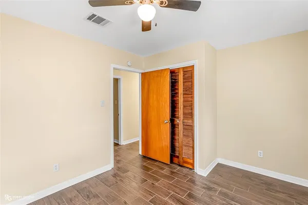 a view of an empty room with wooden floor