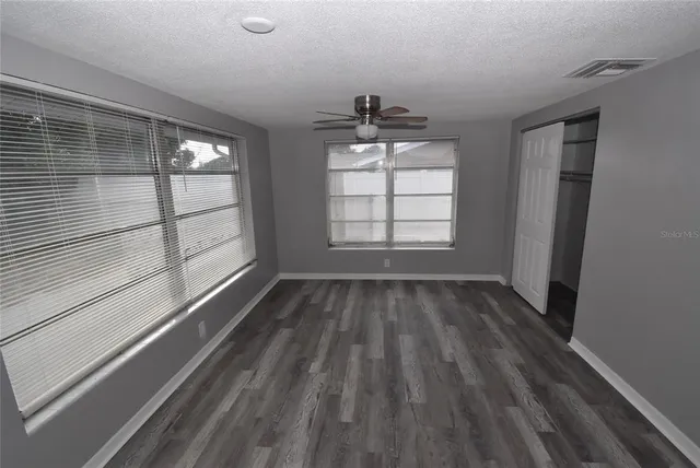 a view of a room with wooden floor and windows