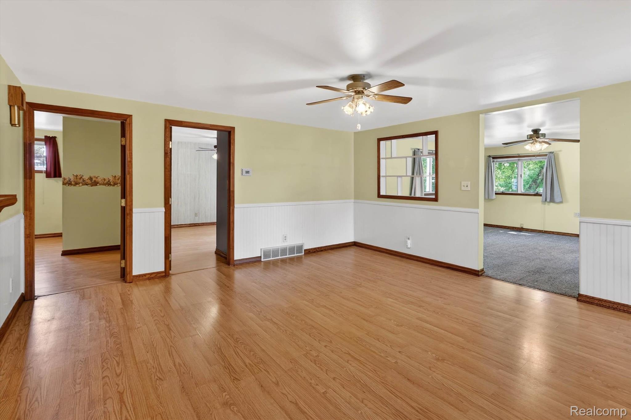 7974 West Gilford Road Reese, MI 48757 - Photo 10 of 36 Empty room featuring wainscoting, light wood finished floors, and a ceiling fan