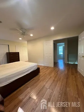 a spacious bedroom with a bed and a wooden floor