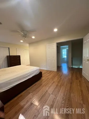 a spacious bedroom with a bed and a wooden floor