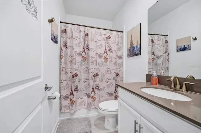 a bathroom with a granite countertop sink a toilet and a mirror