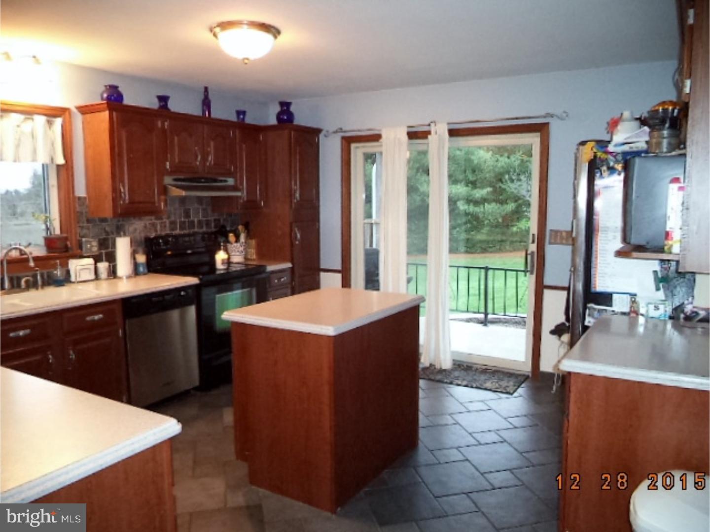 210 Shoemaker Road Bridgeton, NJ 08302 - Photo 4 of 22 a kitchen with a refrigerator a stove top oven a sink a dining table and chairs