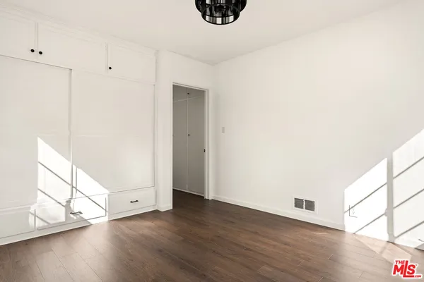 a view of an empty room and wooden floor