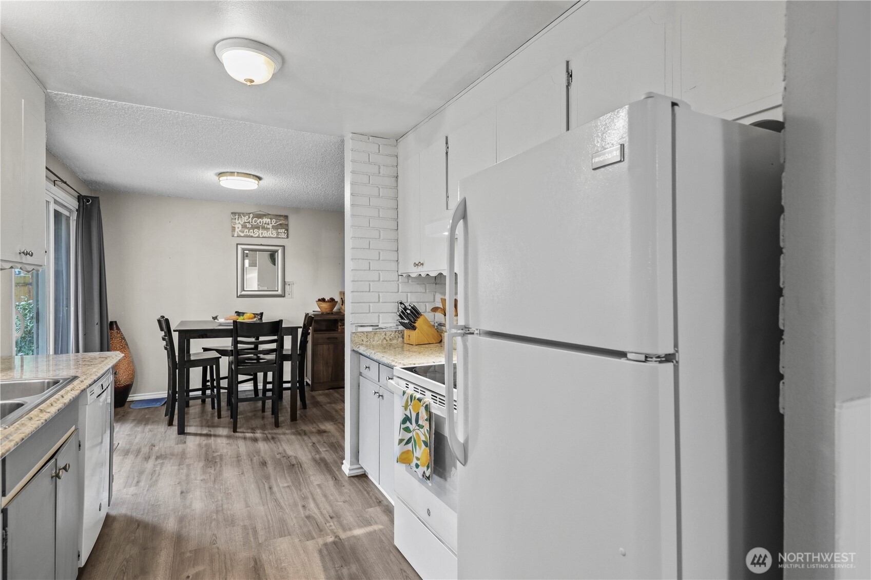 203 South 357th Street Federal Way, WA 98003 - Photo 12 of 28 a kitchen with a refrigerator a dining table and chairs