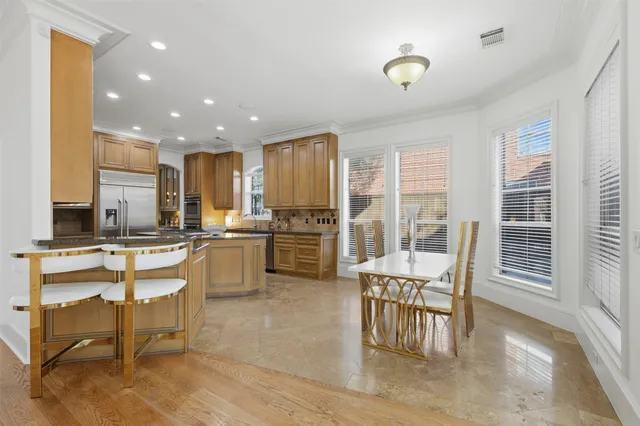 a kitchen with a table chairs refrigerator and cabinets