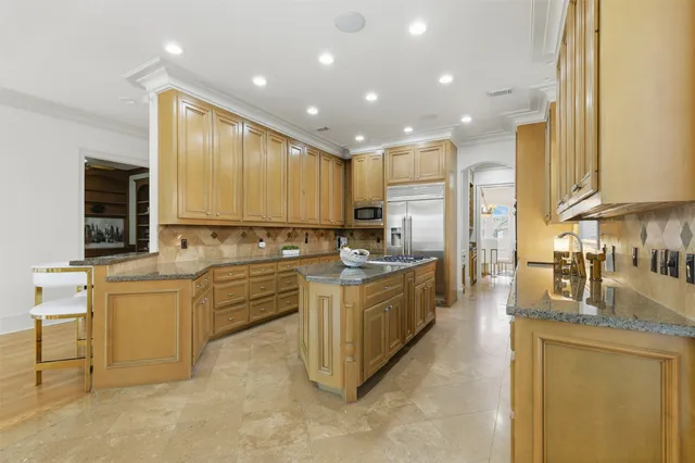 a large kitchen with stainless steel appliances lots of white cabinets