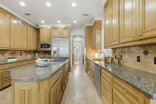 a kitchen with stainless steel appliances granite countertop a sink stove and refrigerator