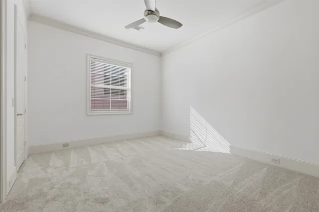 an empty room with a window and ceiling fan