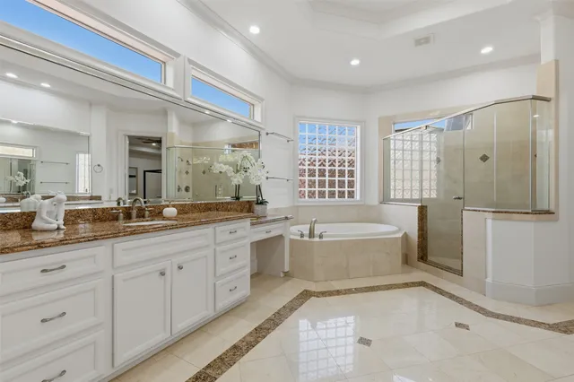 a spacious bathroom with a double vanity sink a mirror and a bathtub