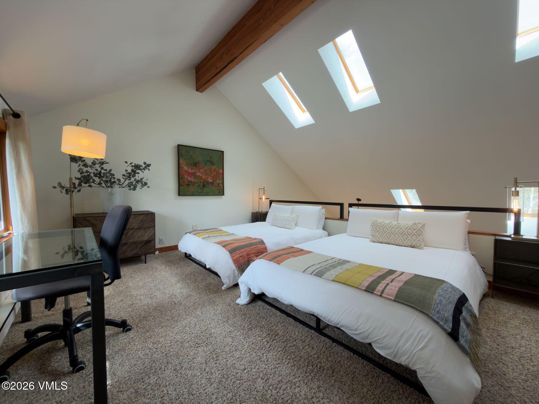 2875 Manns Ranch Road, Unit J2 Vail, CO 81657 - Photo 14 of 25 a bedroom with a bed and a dresser next to a window