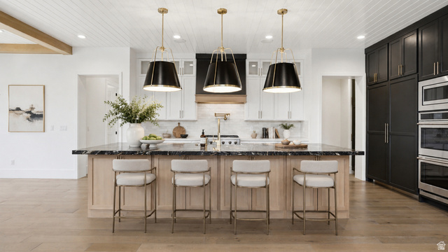 1682 North 1950 W Street, Unit 9 Provo, UT 84604 - Photo 78 of 84 Kitchen featuring a large island with dark stone countertop, light wood-finish cabinetry, and three pendant light fixtures