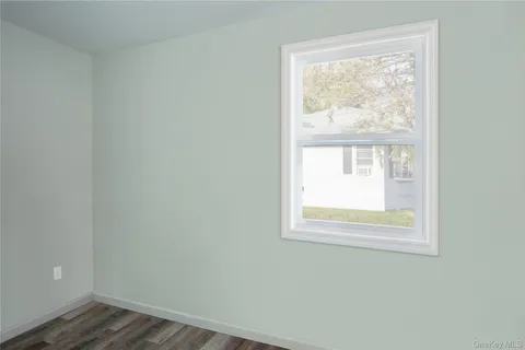 an empty room with wooden floor and a window