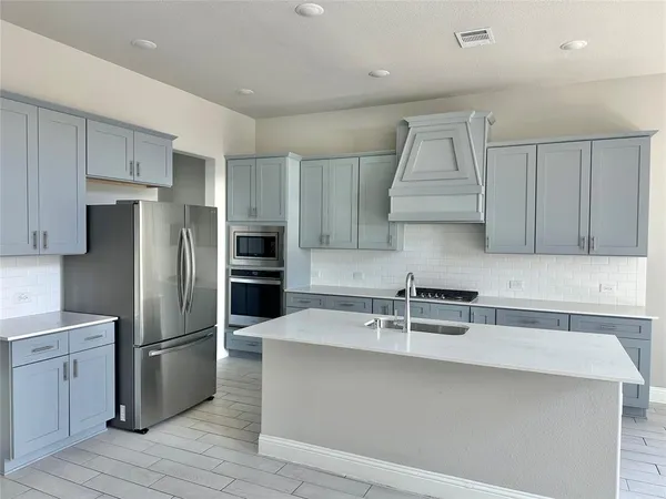 a kitchen with a sink a refrigerator and cabinets