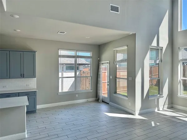 a view of an empty room with glass door and wooden floor