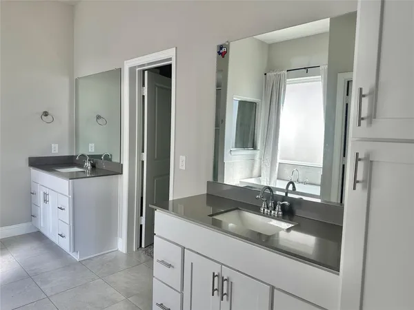 a bathroom with a double vanity sink and mirror