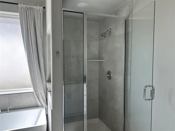 a bathroom with a shower and a glass door