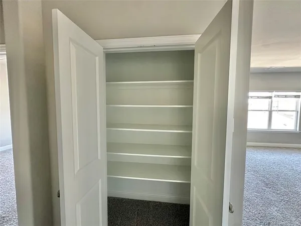 a view of walk in closet with empty racks
