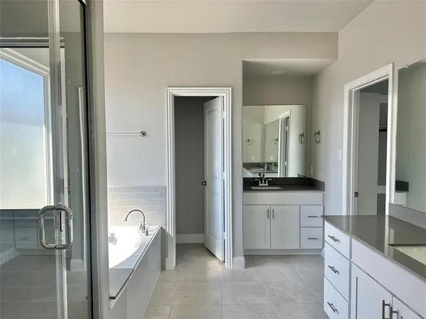 a spacious bathroom with a granite countertop sink mirror and a bathtub