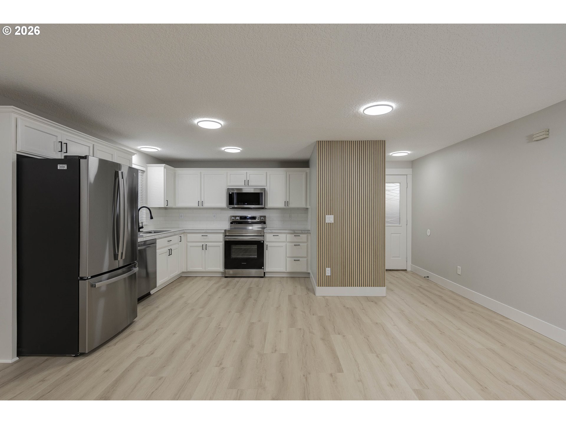 601 West 1st Street, Unit 13 Newberg, OR 97132 - Photo 3 of 30 a kitchen with stainless steel appliances a refrigerator and wooden floor