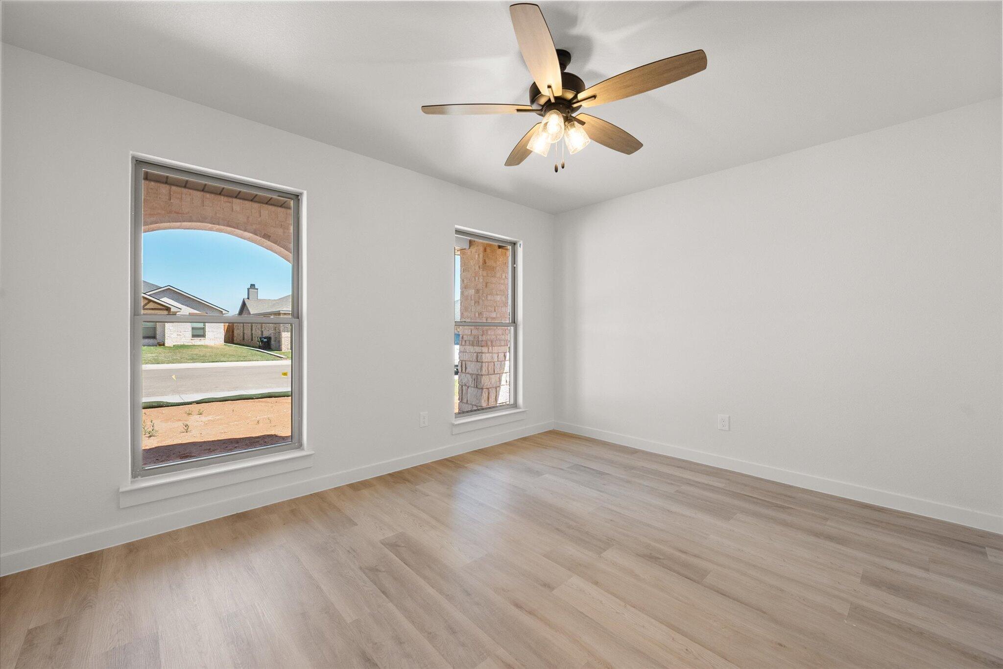 1203 East 30th Street Wolfforth, TX 79382 - Photo 20 of 25 a view of an empty room with a window and wooden floor