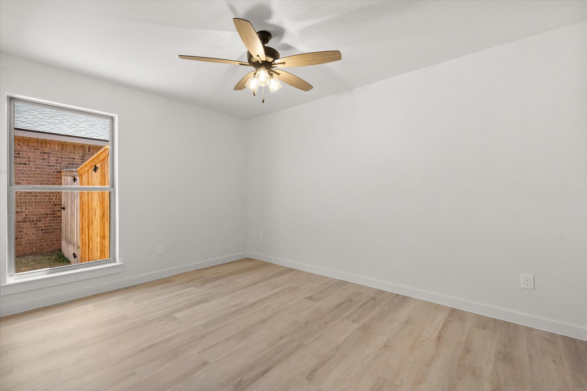 1203 East 30th Street Wolfforth, TX 79382 - Photo 21 of 25 an empty room with a window and a fan