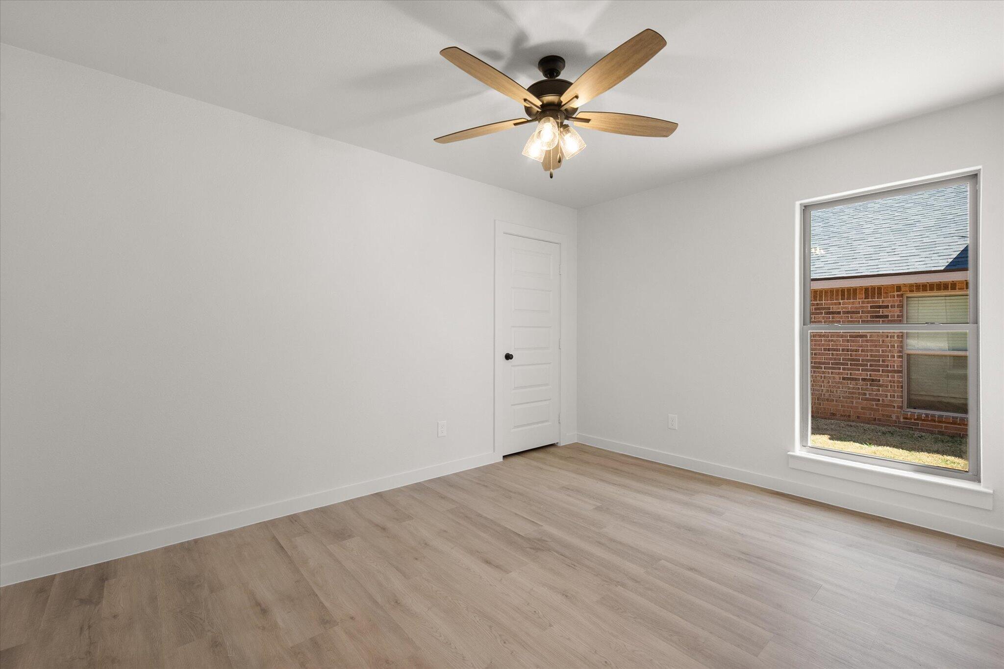 1203 East 30th Street Wolfforth, TX 79382 - Photo 22 of 25 an empty room with a window and a ceiling fan