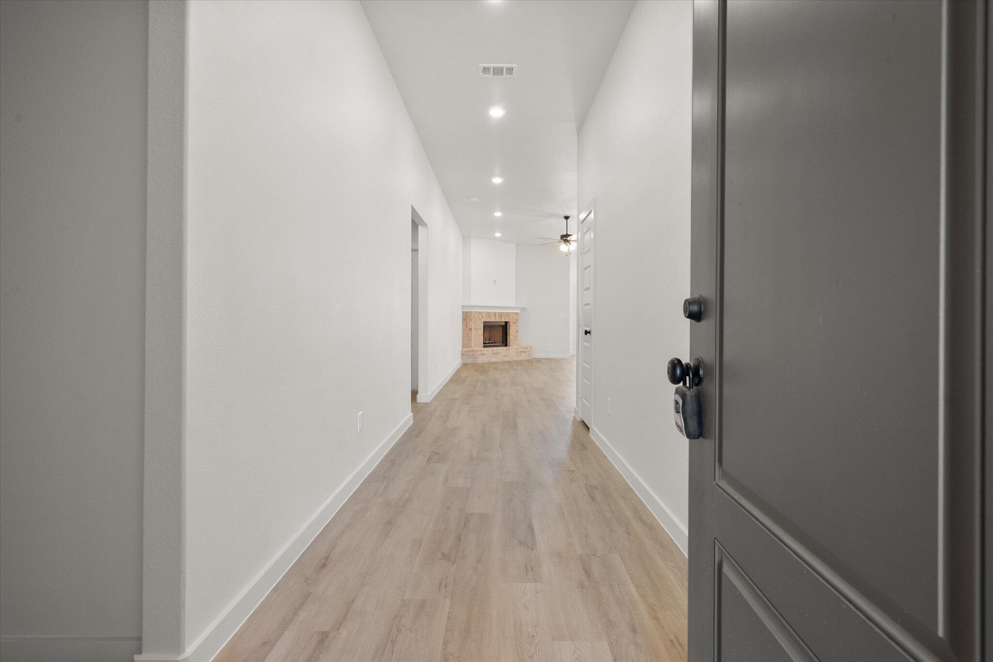 1203 East 30th Street Wolfforth, TX 79382 - Photo 3 of 25 a view of a hallway with wooden floor and a bathroom
