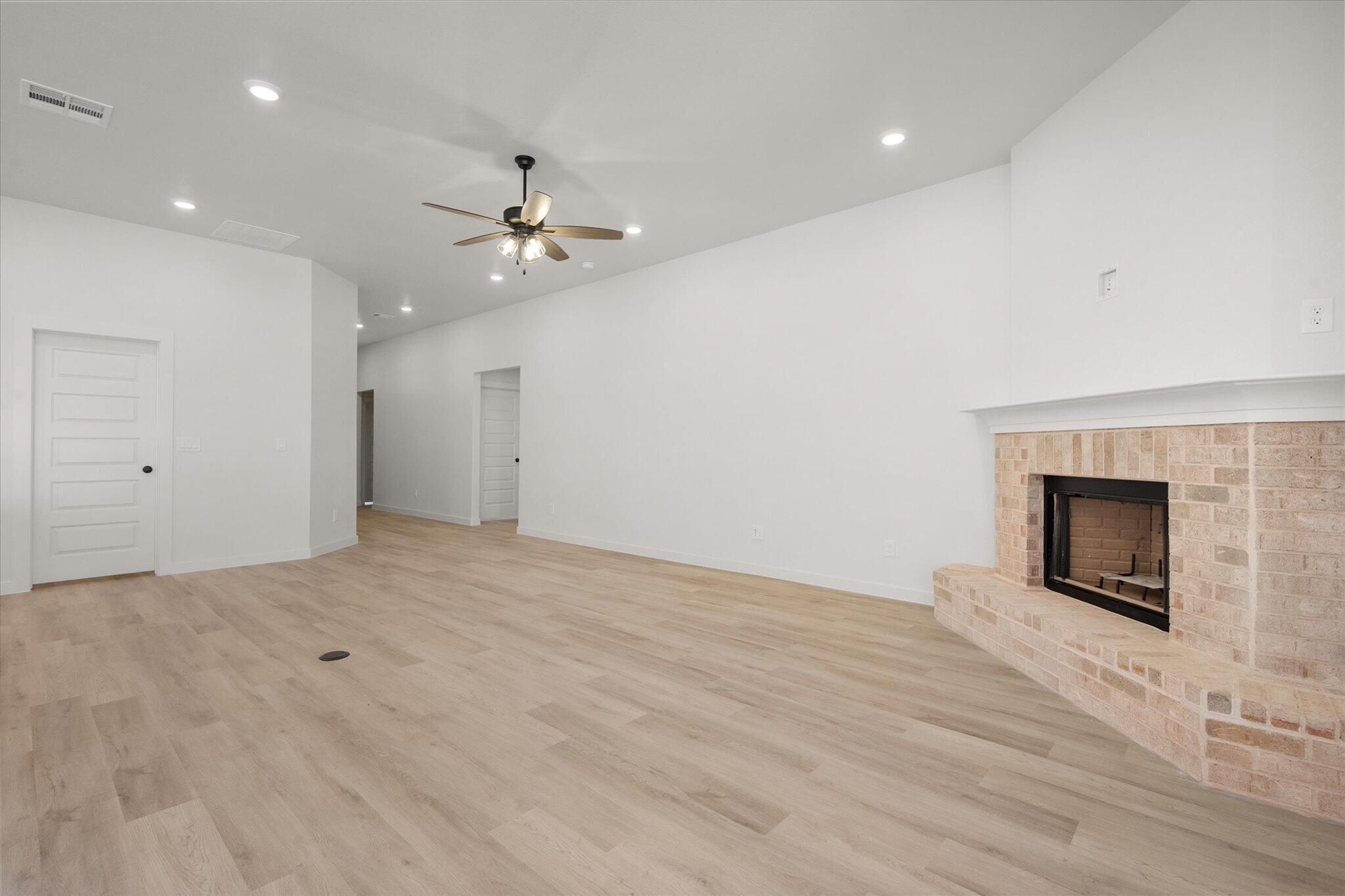 1203 East 30th Street Wolfforth, TX 79382 - Photo 6 of 25 an empty room with fan and fireplace
