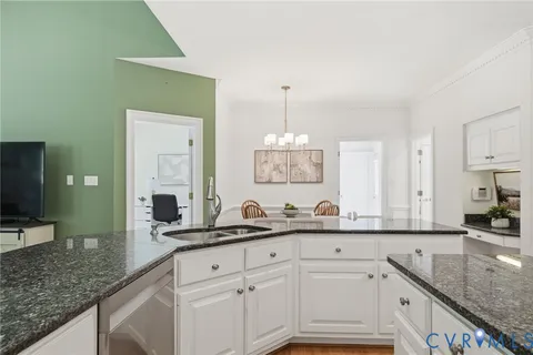 a kitchen with stainless steel appliances granite countertop a sink dishwasher and a refrigerator with wooden floor