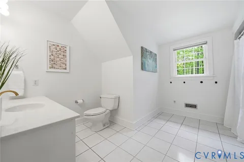 a view of a house with large trees and next to a sink