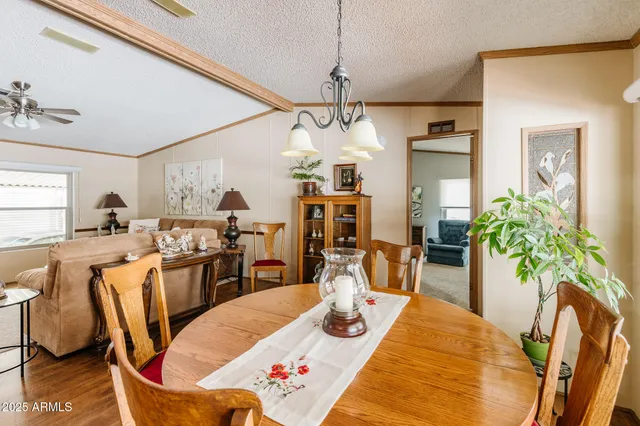 a view of a dining room and livingroom with furniture wooden floor a chandelier