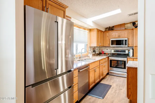 a kitchen with stainless steel appliances granite countertop a refrigerator and a stove top oven