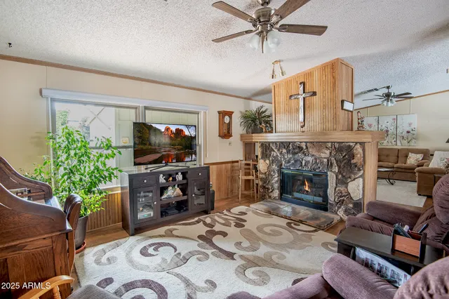 a living room with furniture a flat screen tv and a fireplace