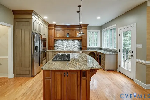 a kitchen with stainless steel appliances granite countertop a sink refrigerator and cabinets