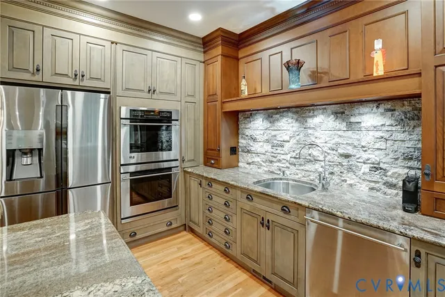 a kitchen with stainless steel appliances granite countertop a refrigerator and a sink