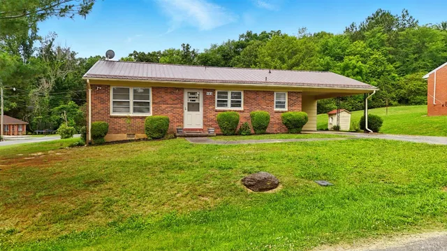 a view of a house with a yard and sitting area