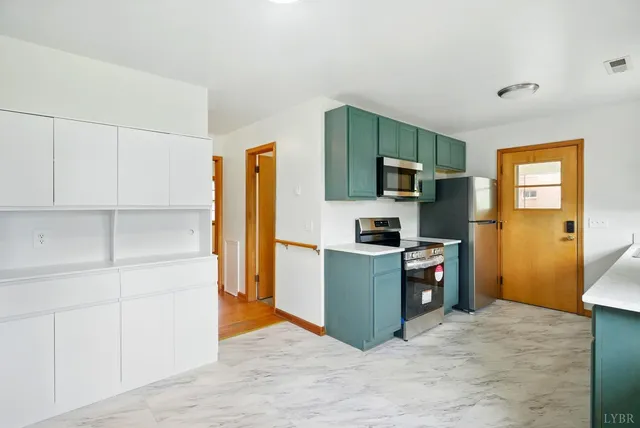 a kitchen with stainless steel appliances a refrigerator and a stove top oven