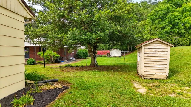 a front view of a house with a yard and trees