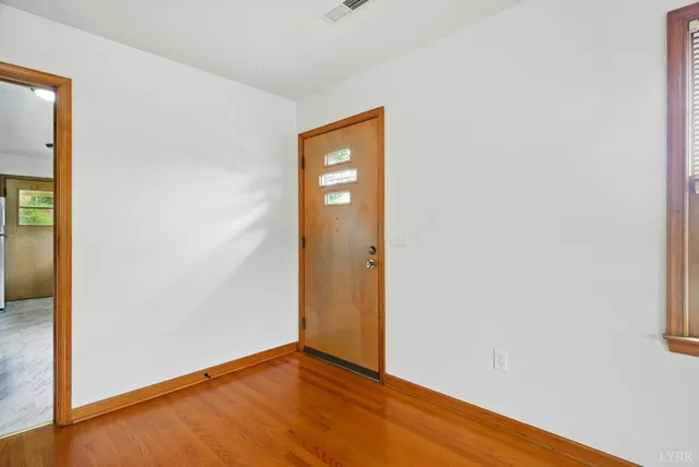 a view of an empty room with wooden floor