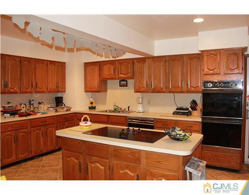 4 Gurley Road Edison, NJ 08817 - Photo 3 of 7 a kitchen with stainless steel appliances a stove a sink a refrigerator and cabinets