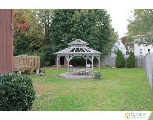 4 Gurley Road Edison, NJ 08817 - Photo 7 of 7 a white house with a small yard and large trees