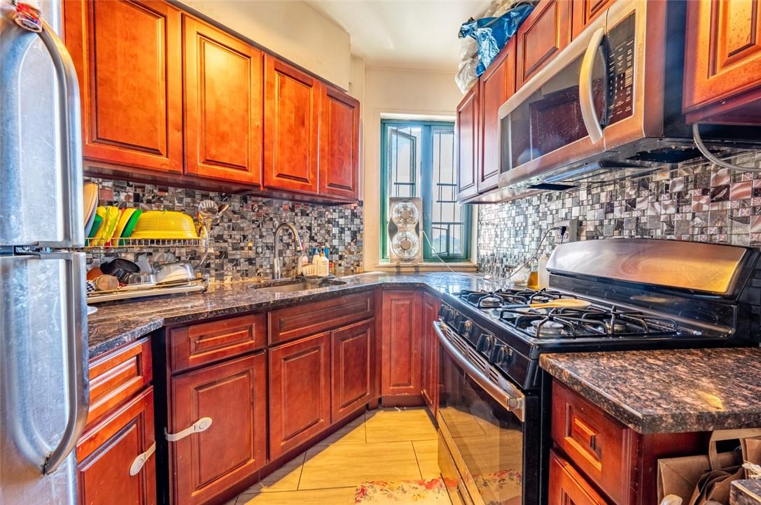 1510 Unionport Road, Unit 6E Bronx, NY 10462 - Photo 1 of 1 a kitchen with stainless steel appliances granite countertop a stove a sink and a wooden cabinets