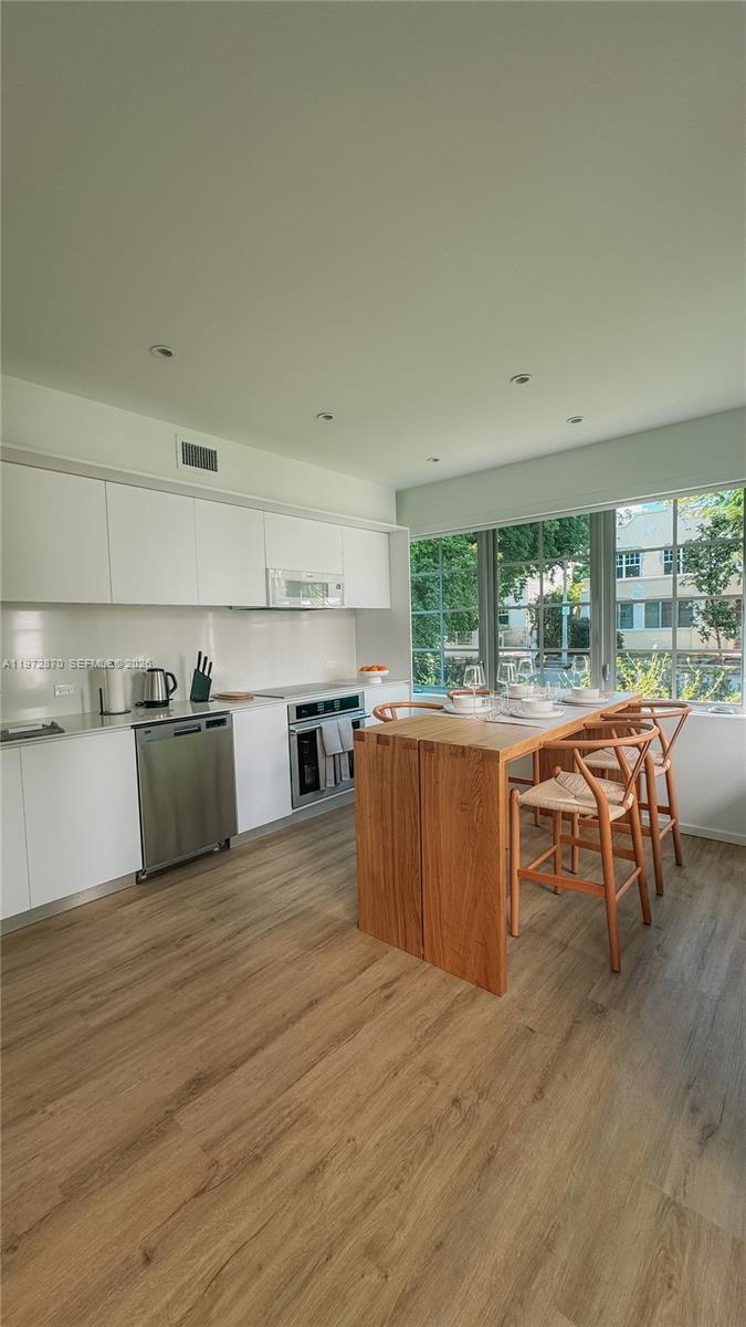 128 Northeast 46th Street, Unit 3 Miami, FL 33137 - Photo 15 of 17 a kitchen with stainless steel appliances granite countertop a stove and a refrigerator