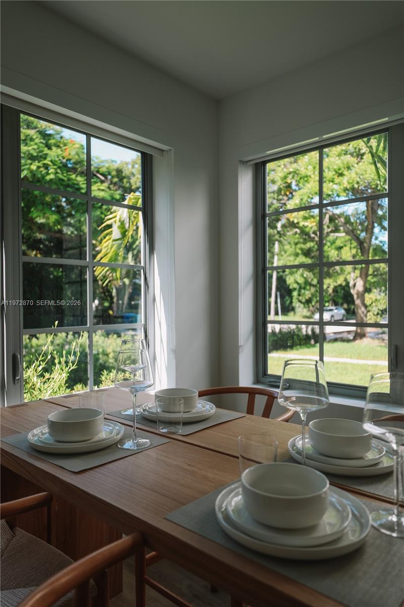 128 Northeast 46th Street, Unit 3 Miami, FL 33137 - Photo 2 of 17 a room with wooden floor and a floor to ceiling window